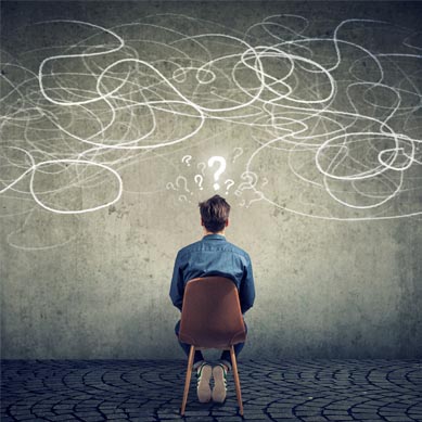 businessman sitting on chair looking at a scribble on a wall feeling confused