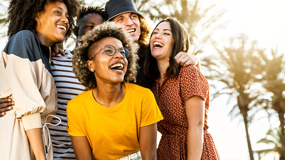 Young people laughing out loud on a sunny day – Cheerful group of best friends enjoying summer vacation together – Human resources, youth lifestyle and summertime holidays concept